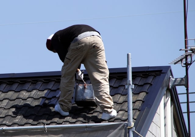 屋根修理をする男性